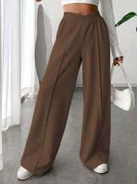 Brown wide-leg pants worn by a person indoors.