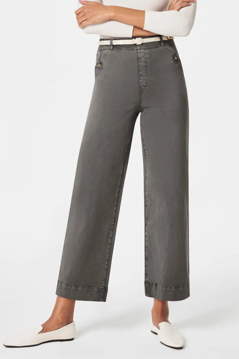Person wearing gray wide-leg pants on a white background