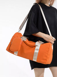 Person holding an orange duffel bag with a white background