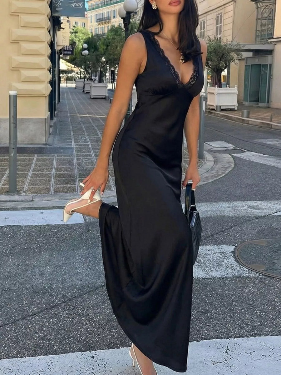 Woman in a black dress crossing a street in an urban setting