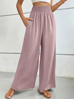 Person wearing pink wide-leg pants against a white background