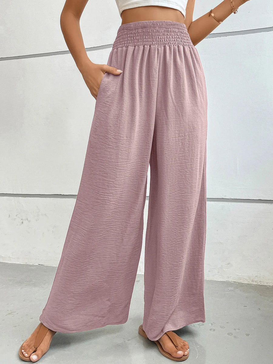 Person wearing pink wide-leg pants against a white background