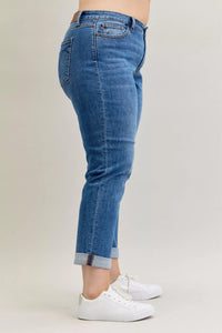 Blue jeans worn by a person on a plain background