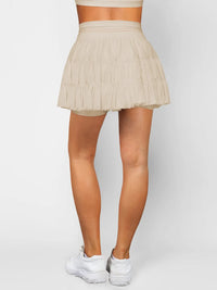 Beige pleated skirt worn by a person on a plain background