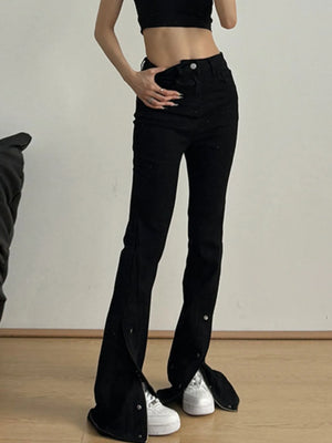 Person wearing black flared jeans and a black crop top on a plain background