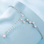 Silver bracelet with star-shaped charms on a light blue background