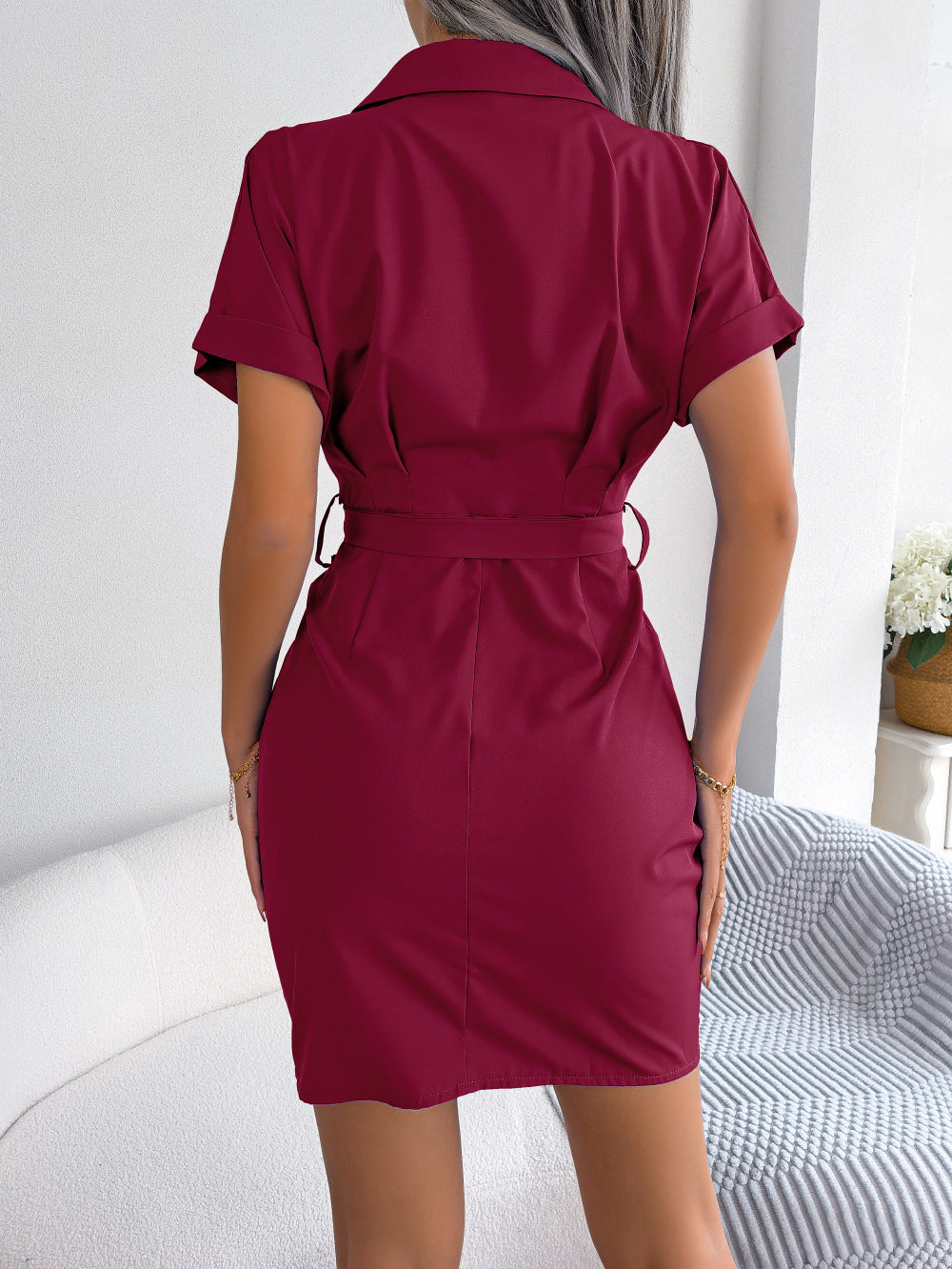Woman wearing a burgundy dress with a white background