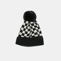 Black and white checkered beanie with a pom-pom on a light gray background