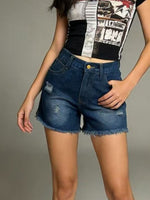 Person wearing a black and white patterned top with blue denim shorts on a gray background