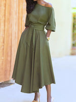 Woman wearing an olive green dress with a blurred background