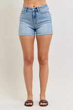 Light blue denim shorts worn by a person on a plain background