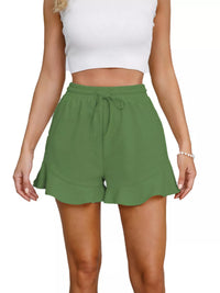 Green shorts worn by a person on a white background