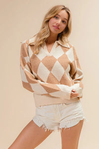 Woman wearing a diamond patterned sweater and white shorts on a beige background