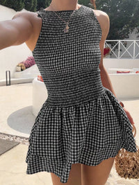 Person wearing a black and white checkered dress outdoors.