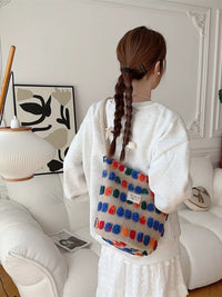 Person wearing a colorful backpack in a room with a white couch and decorative items.