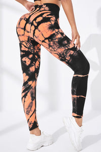 Tie-dye leggings with black and orange pattern on a white background