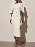 Woman wearing a white dress with cape sleeves against a plain background