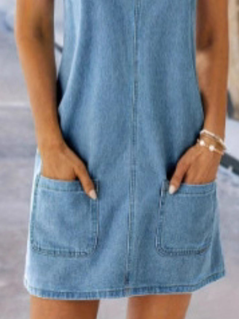 Denim dress with pockets worn by a person, blurred background