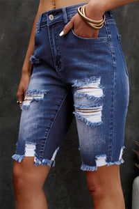 Denim shorts with distressed details on a dark background