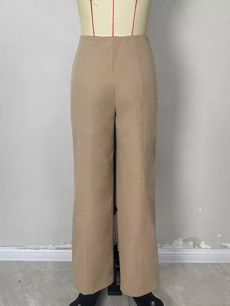 A pair of high-waisted, wide-leg trousers in a light tan/beige color, displayed on a dress form mannequin against a plain gray wall.