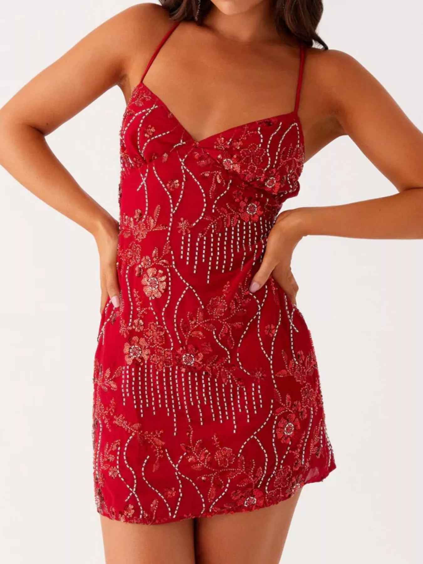 Red dress with floral patterns and embellishments on a white background