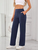 Person wearing navy wide-leg pants with a white background