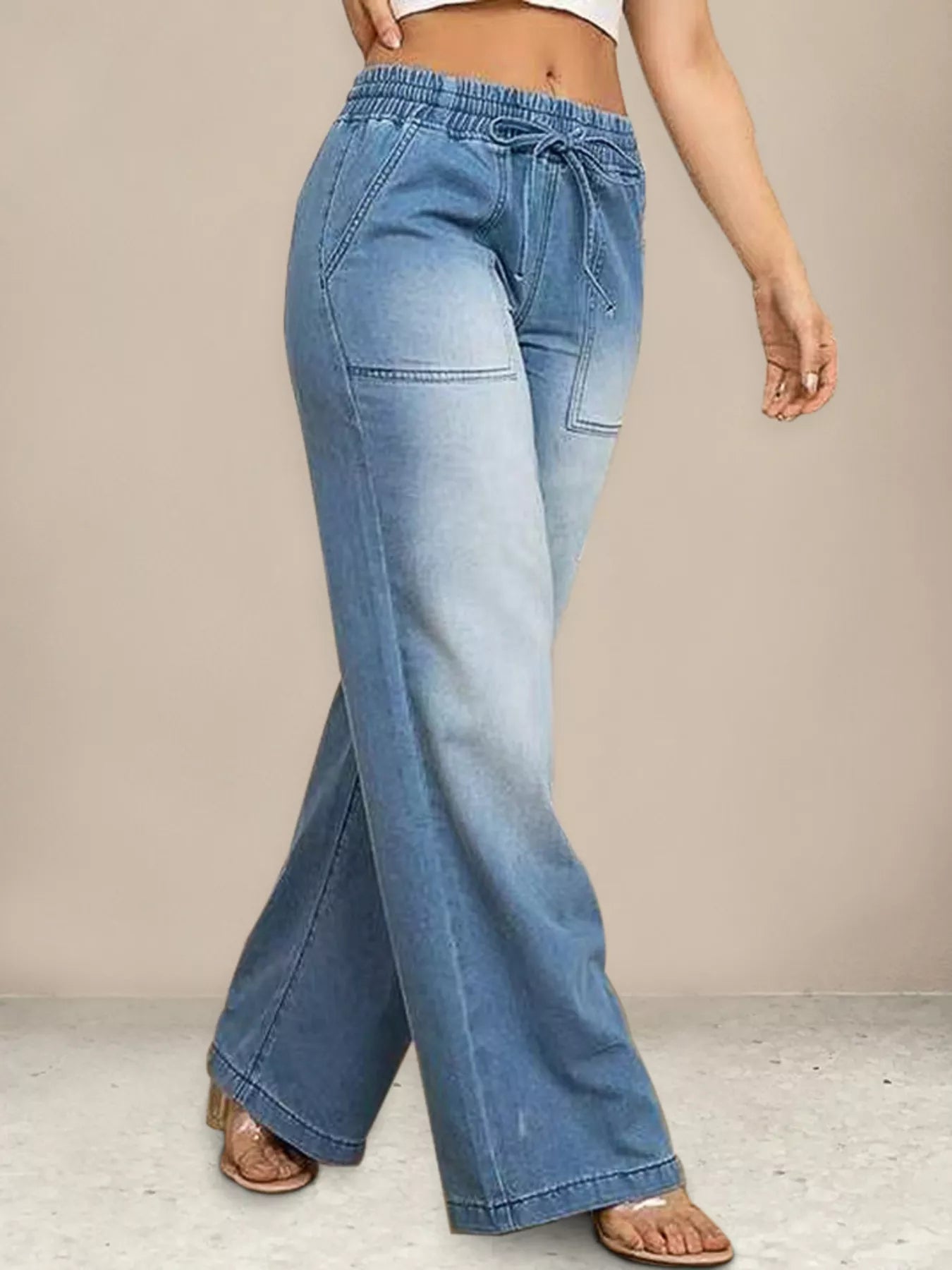 Light blue jeans worn by a person on a neutral background