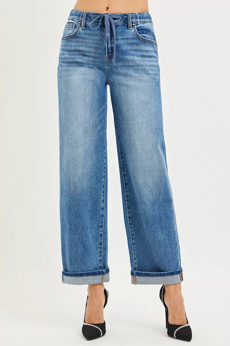 Blue jeans with a tie-waist design on a light gray background