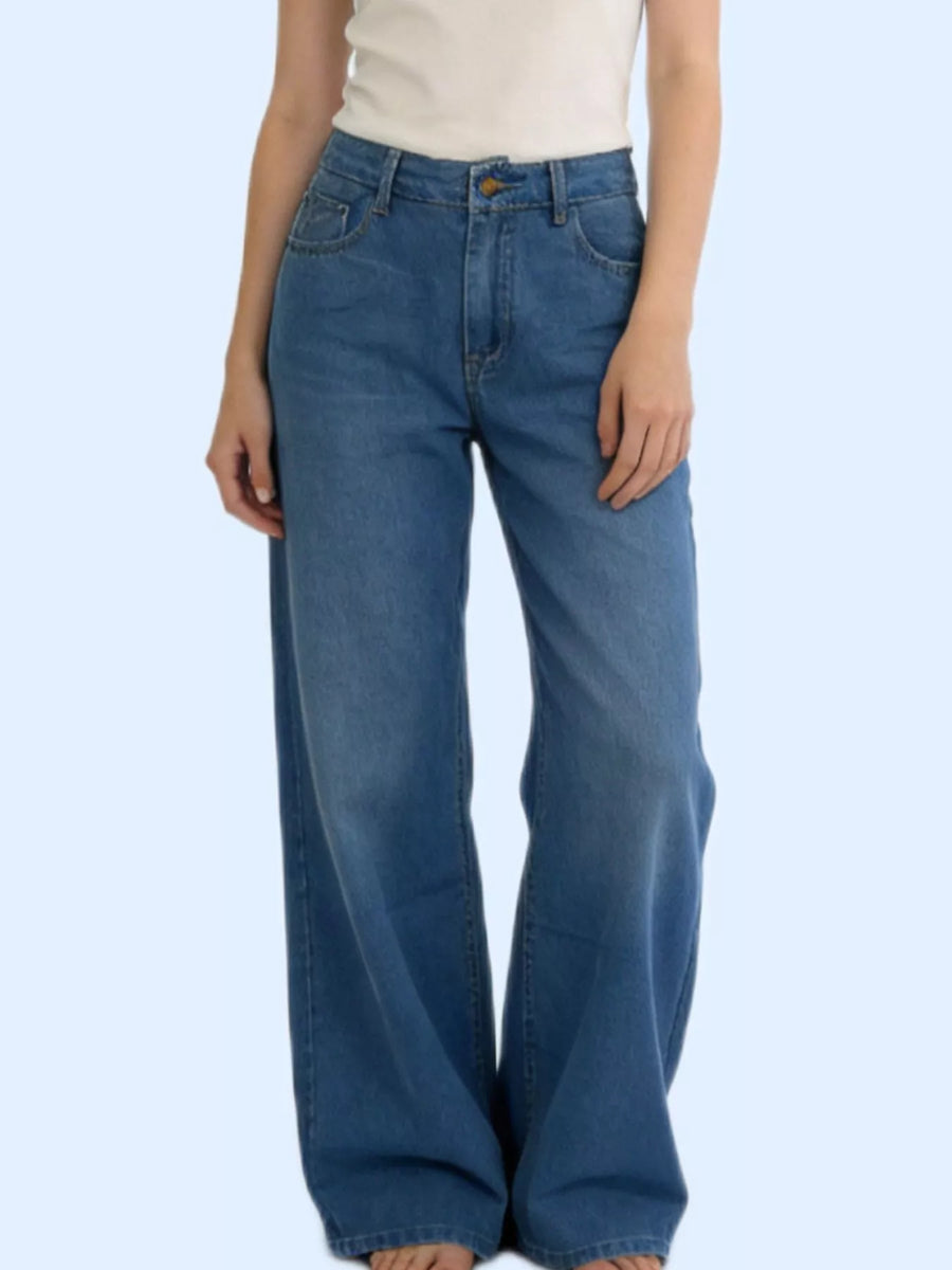 Person wearing blue jeans on a light blue background