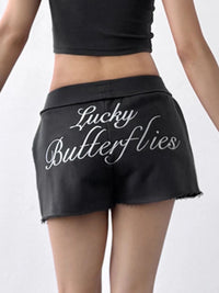 Black shorts with 'Lucky Butterflies' text on a white background