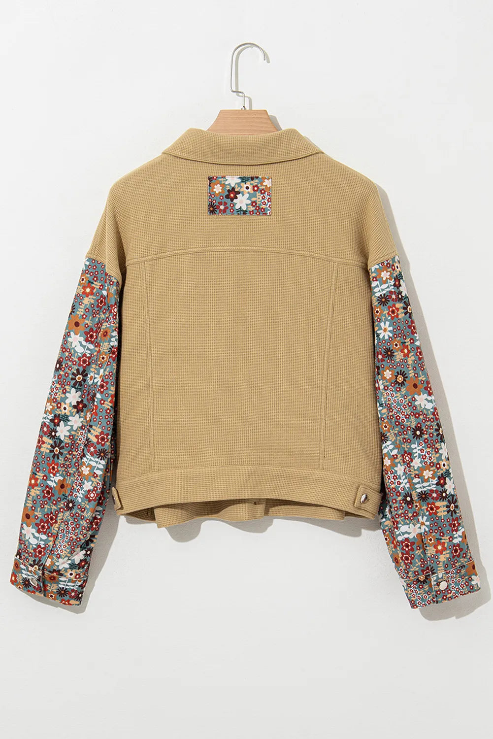 Beige jacket with floral sleeves on a white background