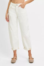 Person wearing white jeans on a plain background