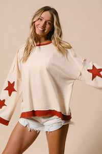 Woman wearing a white sweater with red star patterns on a beige background