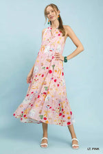 Woman wearing a light pink dress with colorful pattern on a light blue background