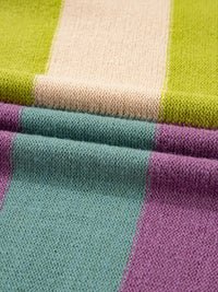 Close-up of fabric with green, beige, purple, and teal stripes.