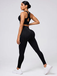 Woman wearing a black athletic outfit on a white background