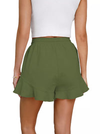 Green shorts worn by a person on a white background