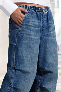 Blue jeans worn by a person with a blurred background