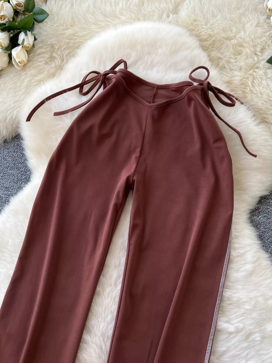 Maroon pants with tie details on a fluffy white surface