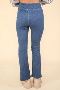 Blue jeans worn by a person on a beige background