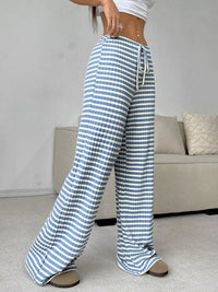 Person wearing blue and white striped pants in a living room setting