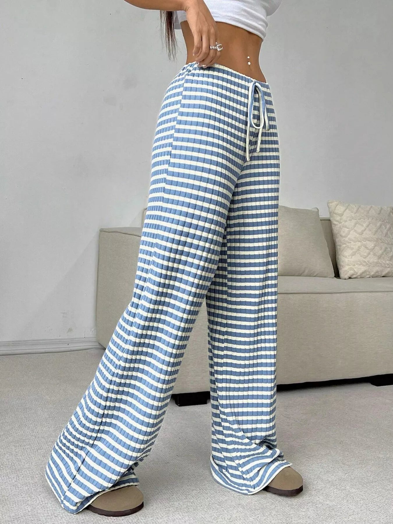 Person wearing blue and white striped pants in a living room setting
