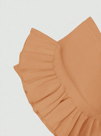 Close-up of a brown ruffled fabric on a light gray background