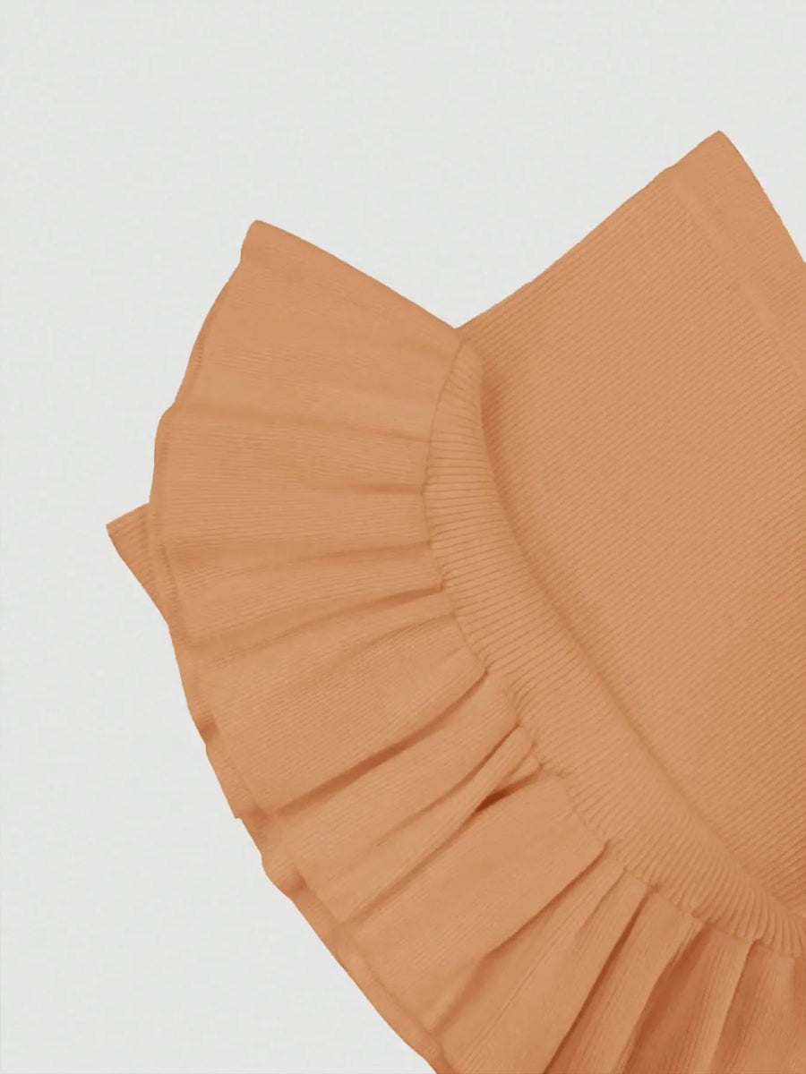 Close-up of a brown ruffled fabric on a light gray background