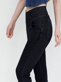 Black jeans worn by a person on a white background