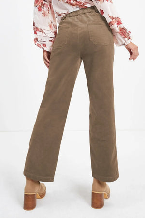 Brown pants worn by a person on a white background