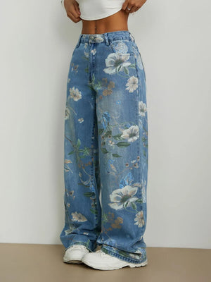 Blue floral jeans worn by a person on a plain background