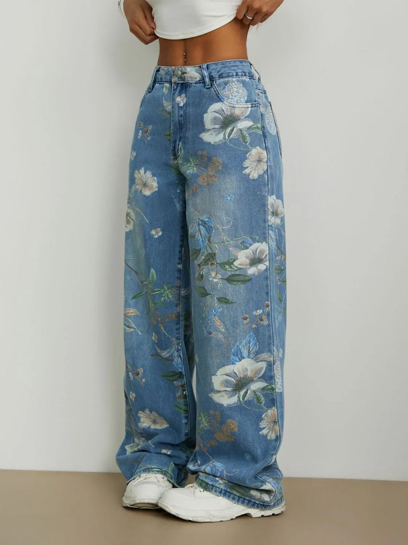 Blue floral jeans worn by a person on a plain background
