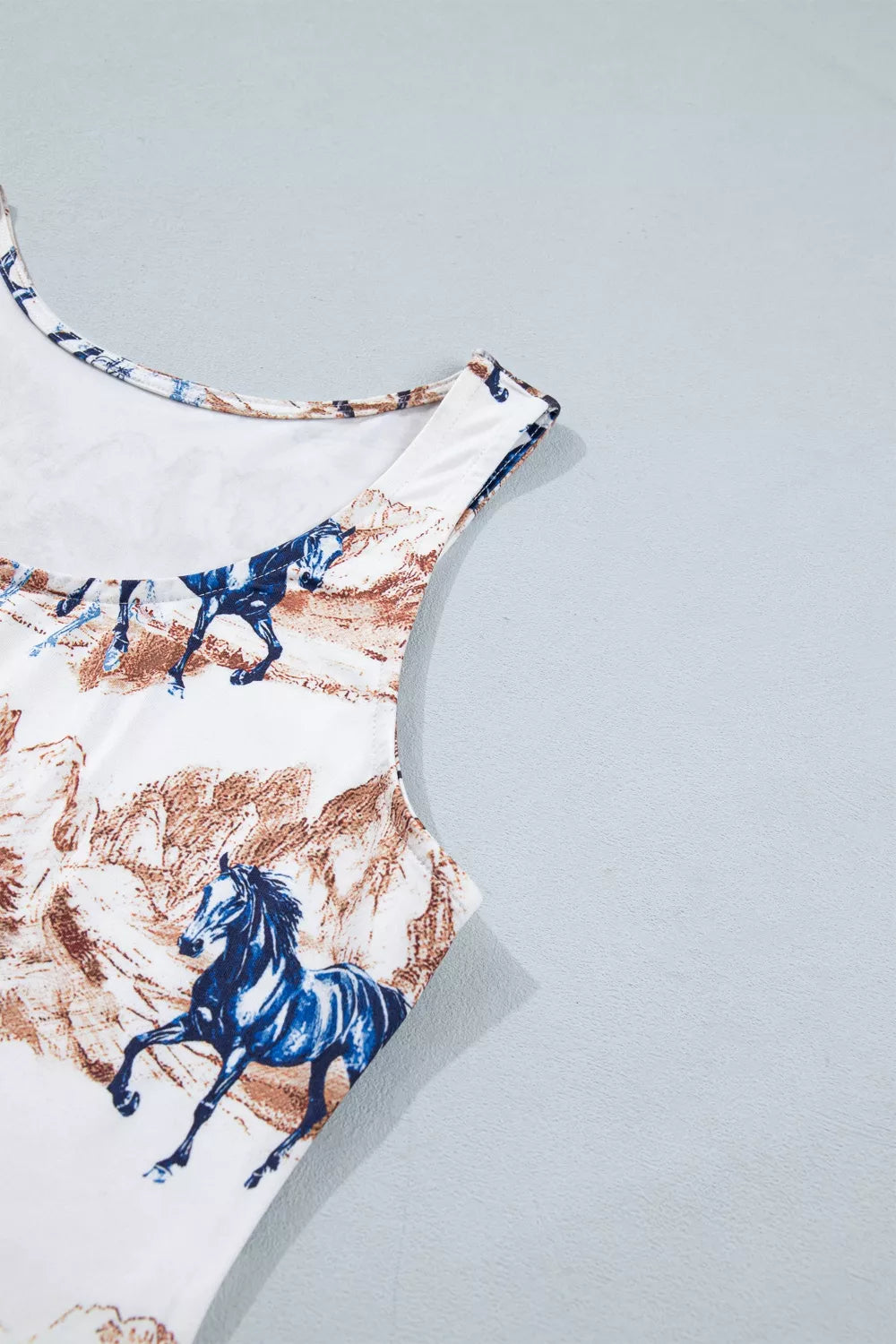 One-piece swimsuit with horse print on a light gray background