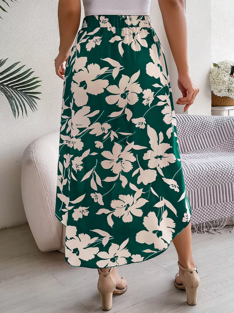 Person wearing a green floral skirt in a room with a couch and plant.